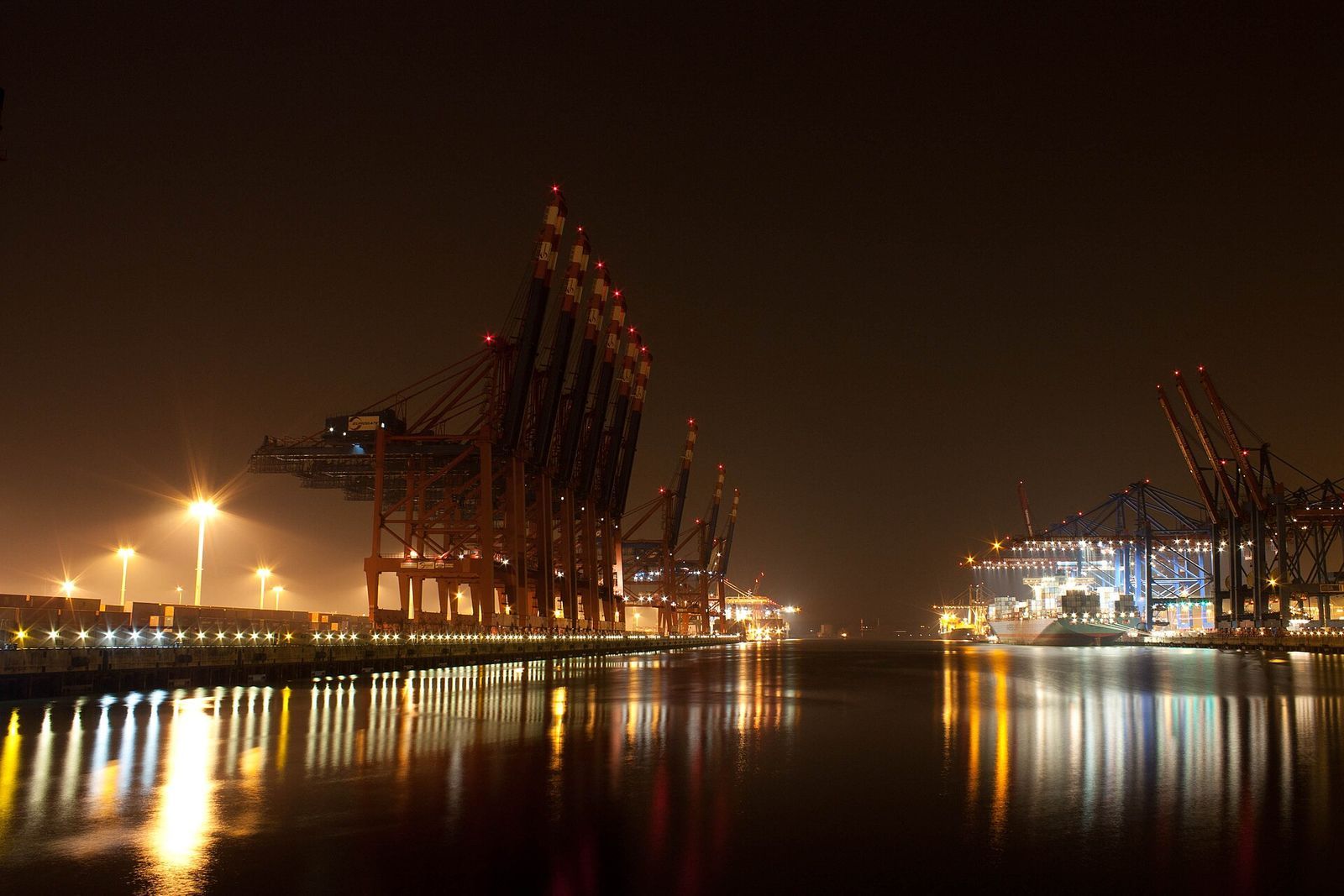 Container port illuminated at night during transit operations